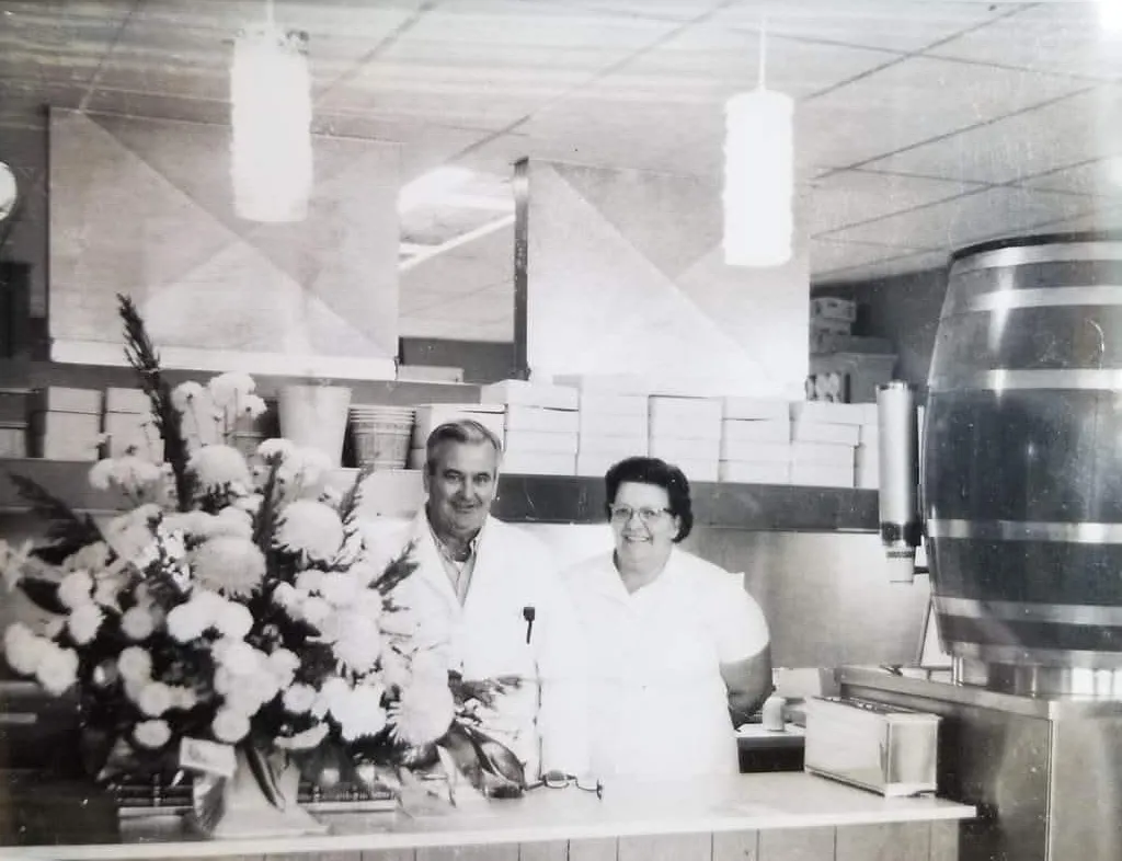 The founding family smiling behind the counter in The Coop's early years
